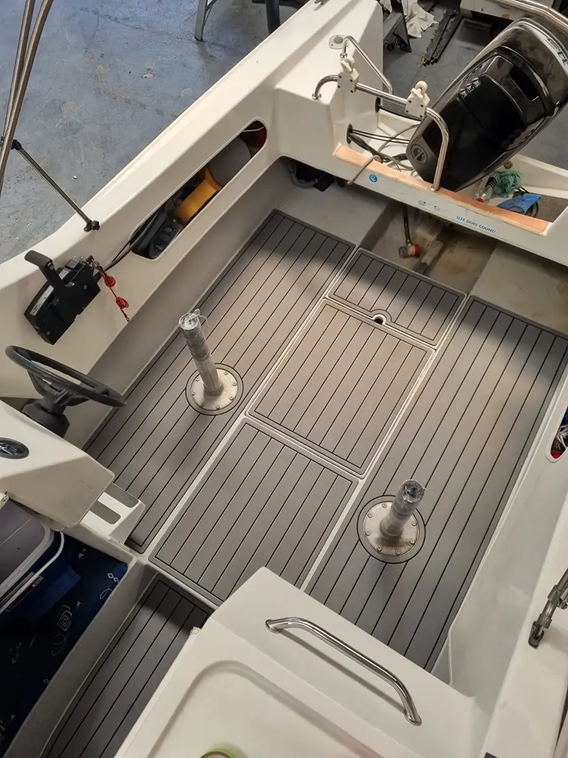Gray custom marine flooring installed across a boat cockpit deck